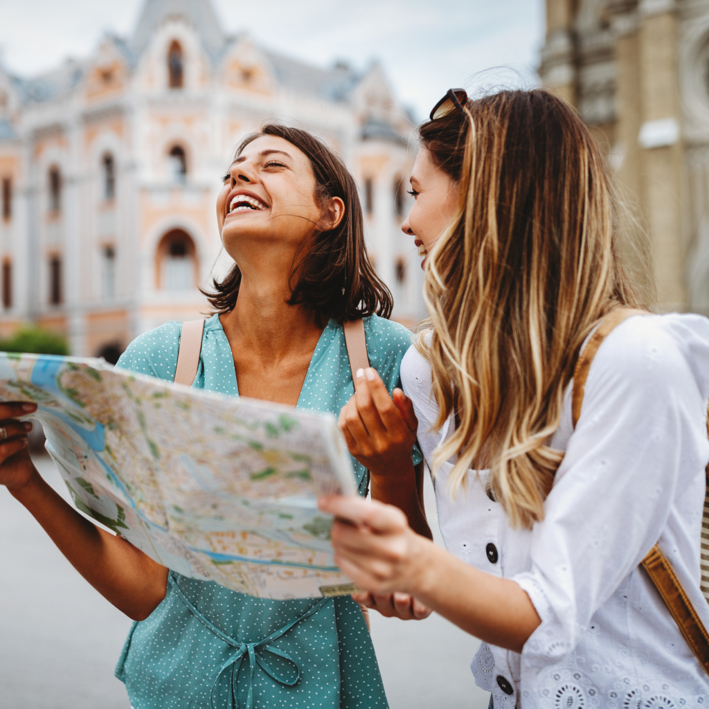 Two women looking at a map and laughing.