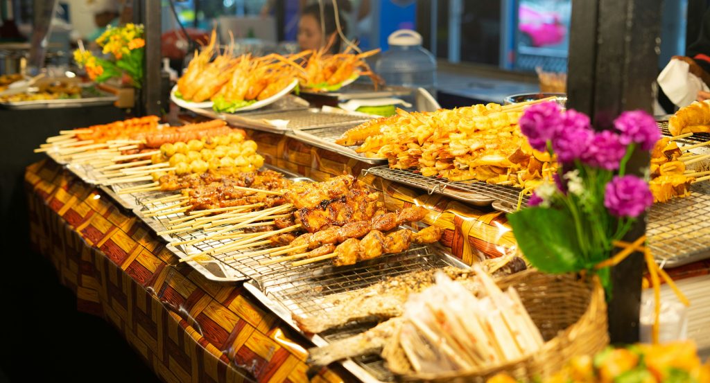 Freshly cooked seafood and skewers on display at a vibrant Bangkok night market