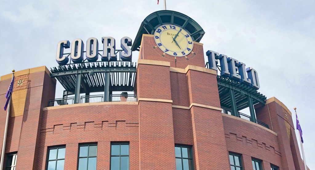 Rooftop deck at Coors Field in Denver with people enjoying drinks and city views
