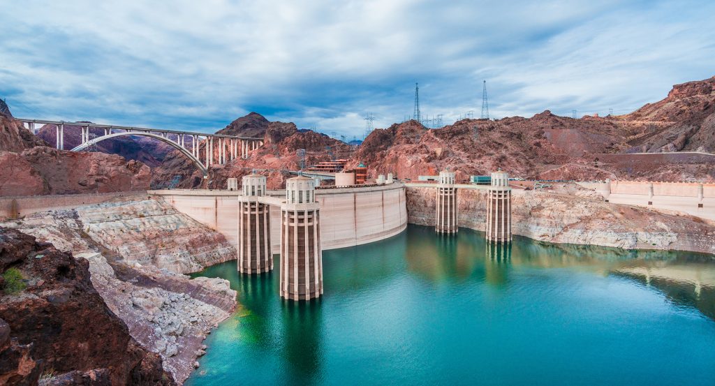 Panoramic view of Hoover Dam with bypass bridge and rugged canyon landscape