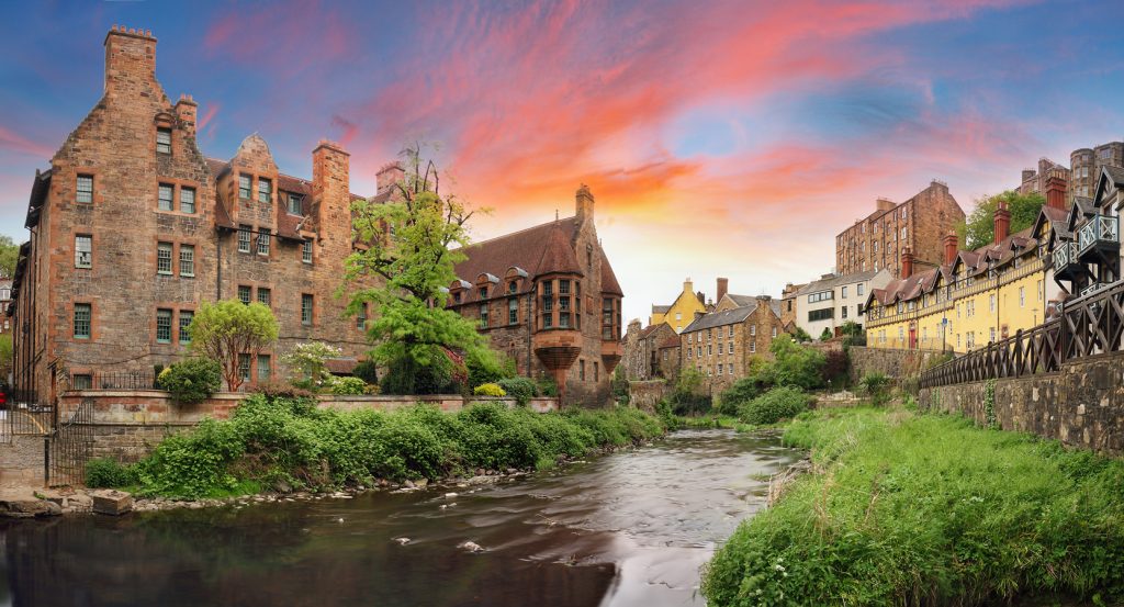Water of Leith flowing through Dean Village surrounded by old stone houses.