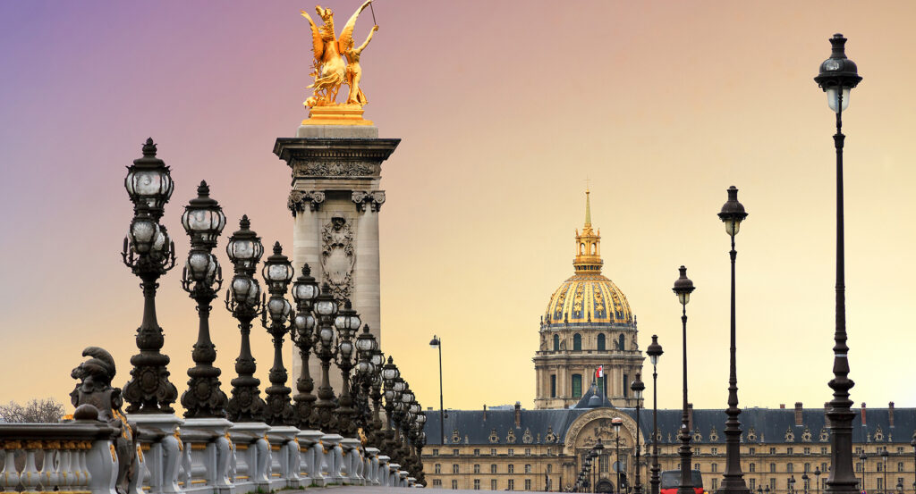 Golden winged statues atop Pont Alexandre III at sunset