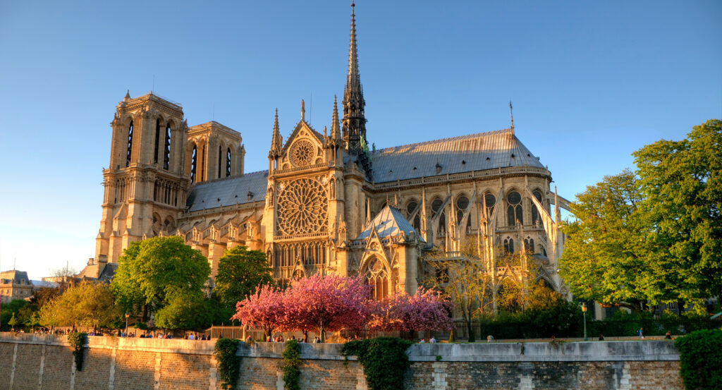 Sunset view of Notre Dame Cathedral framed by trees in Paris