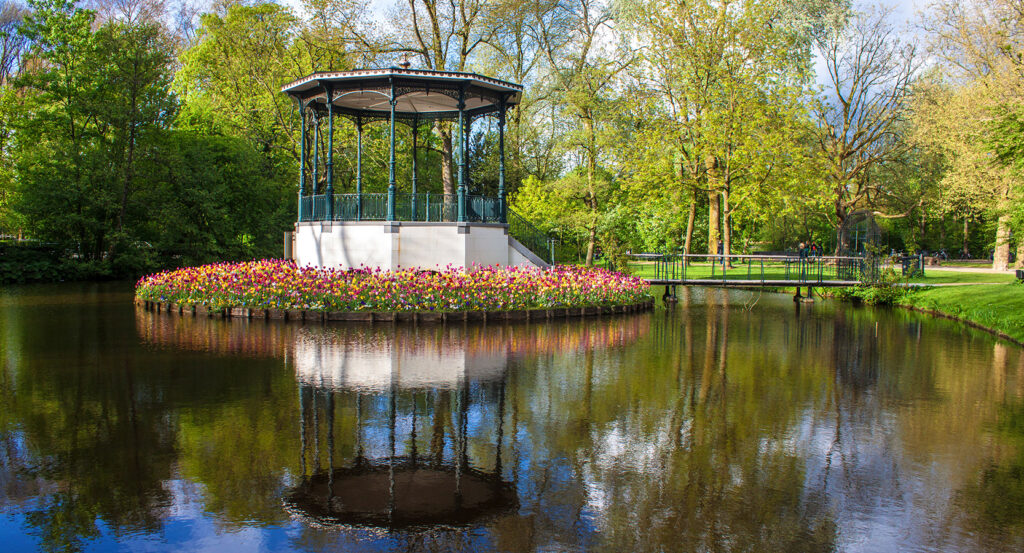 Gazebo and tulip flowers reflected in the water at Vondelpark, Amsterdam