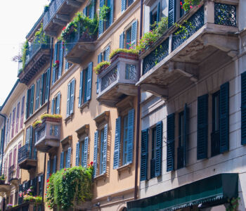 Colorful shuttered balconies and ivy-wrapped façades on a classic residential street in Milan’s Brera district.