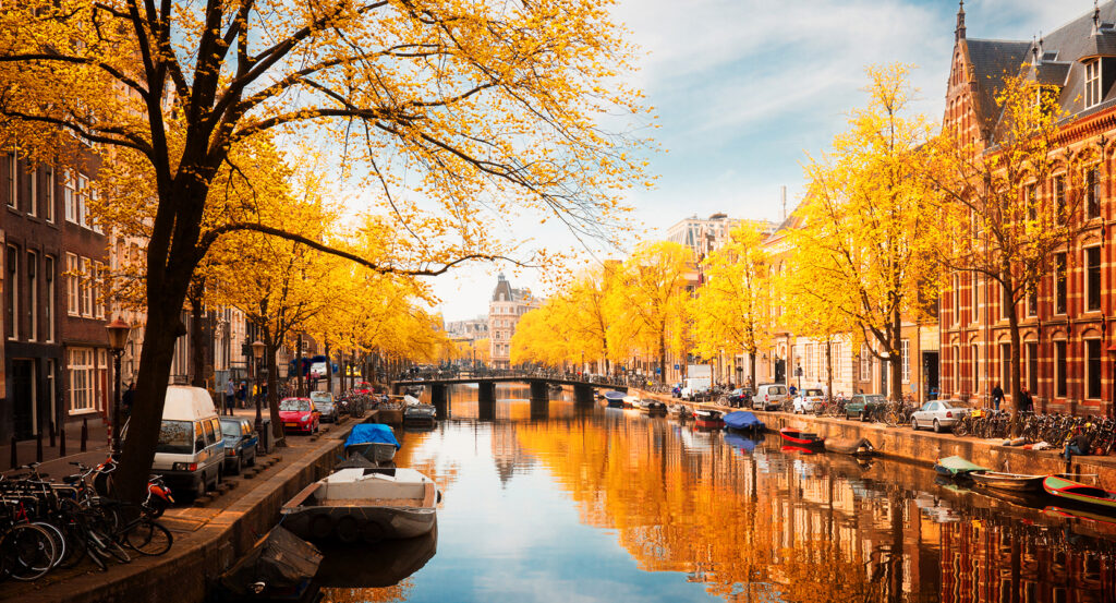 Evening view of Amsterdam’s Canal Ring with bridges and lights.