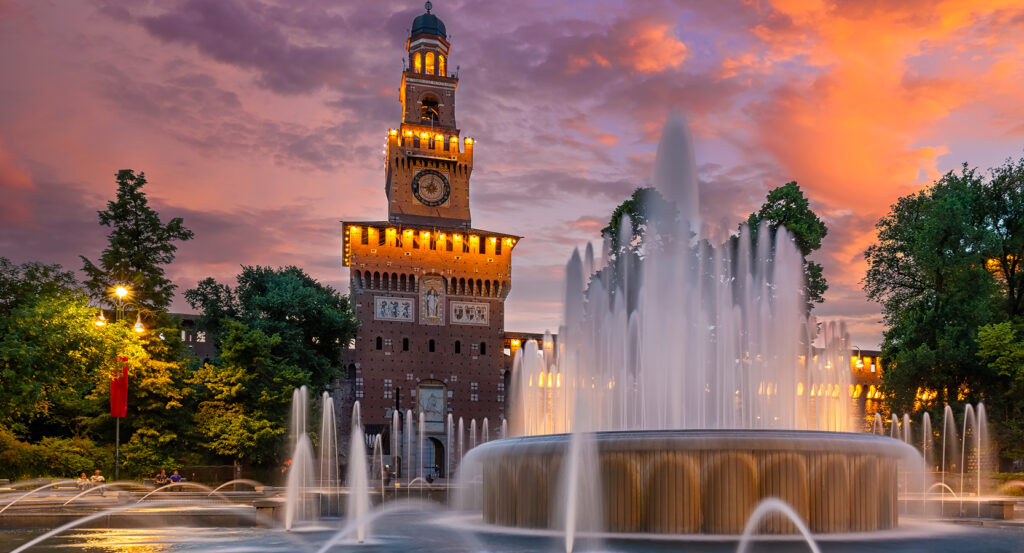 Castello Sforzesco tower illuminated against colorful evening sky