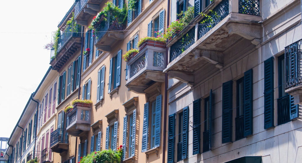 Street view of Milan’s Brera District with historic buildings and vibrant window gardens