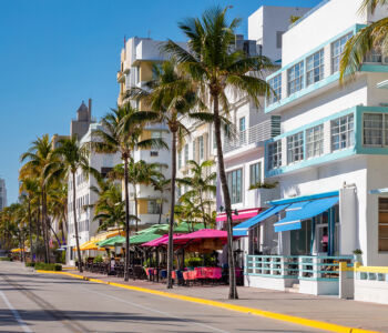 Colorful Art Deco buildings and palm trees along Ocean Drive in South Beach, Miami's iconic beachfront entertainment district.