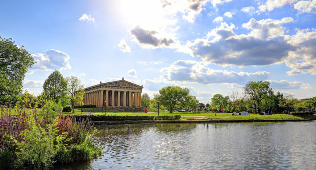 The Parthenon in Nashville surrounded by trees and open parkland
