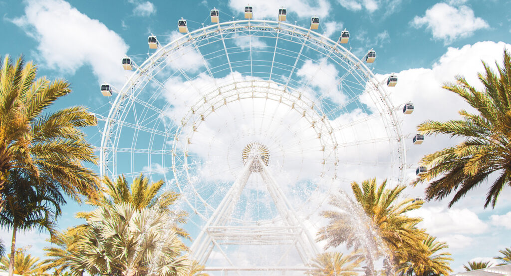 Daytime view of the Orlando ICON Park Ferris wheel with fountains in front.