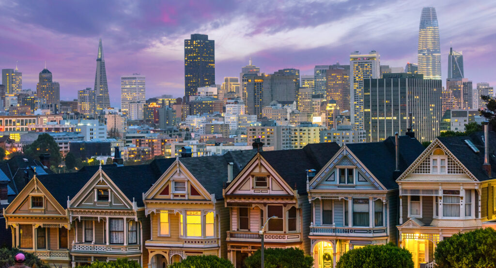 Colorful row of Painted Ladies houses in San Francisco with city backdrop