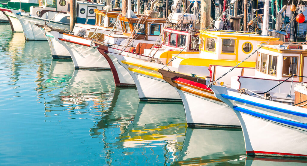 Vibrant waterfront view of San Francisco’s Fisherman’s Wharf with boats and reflections