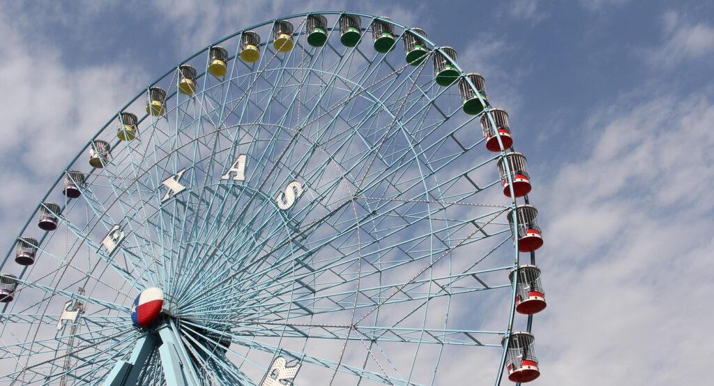 Fair Park Ferris Wheel rising above Dallas with colorful gondolas