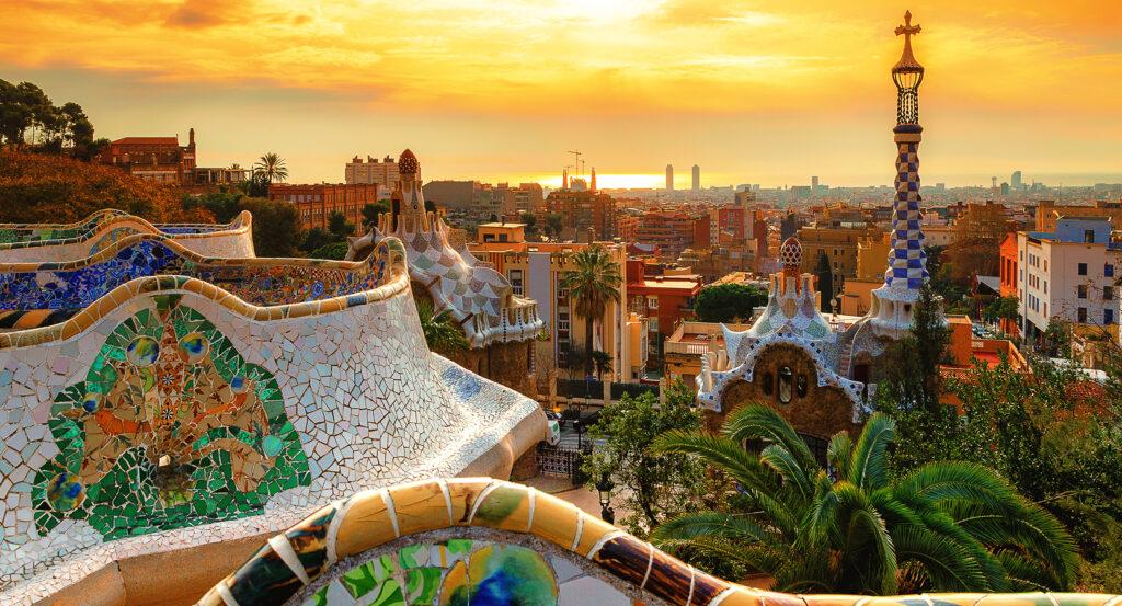 Colorful mosaic bench and city skyline from Park Güell