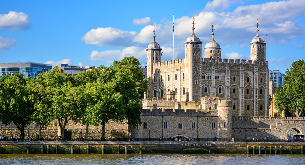 The Tower of London with its stone walls and turrets under blue sky