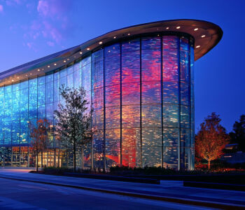 Georgia Aquarium illuminated at night in downtown Atlanta with vibrant blue and purple lighting.