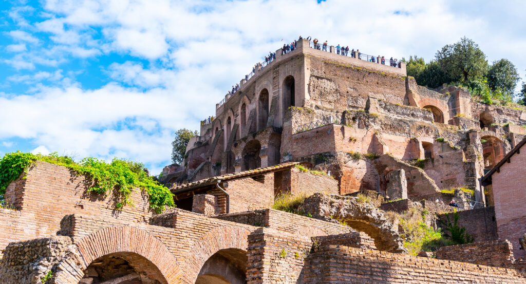 Ancient brick ruins and arches of Palatine Hill in Rome under a bright blue sky
