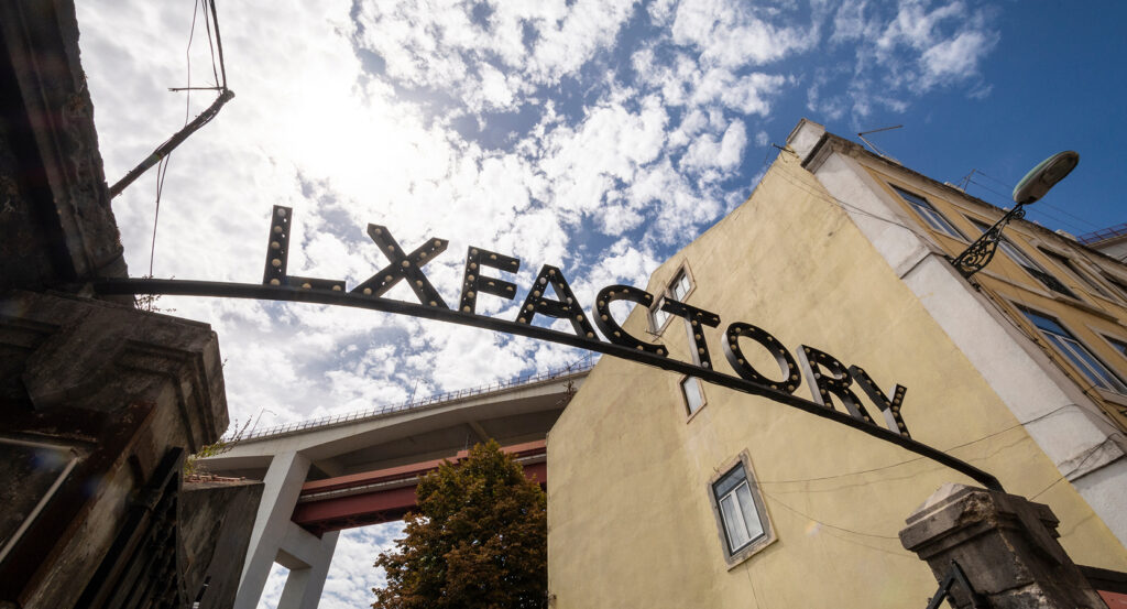 Historic LX Factory gateway arch with buildings and sky in Lisbon, Portugal.