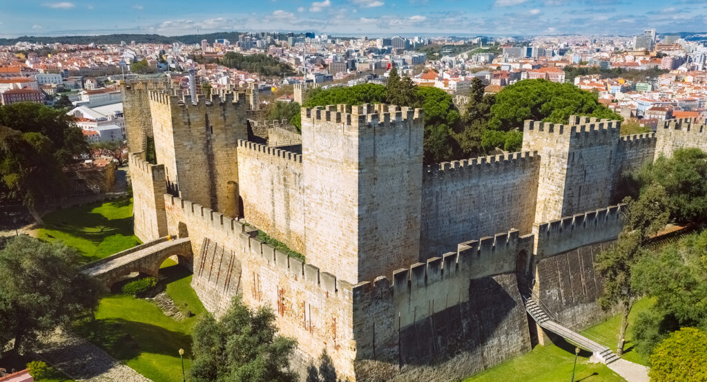 Stone walls and towers of Castelo São Jorge in Lisbon with city skyline in the background