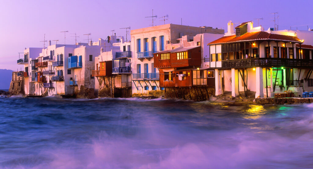 Iconic waterfront balconies of Little Venice in Mykonos during twilight.