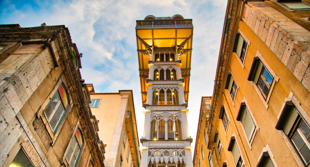 Gothic iron Santa Justa Lift tower lit at sunset in Lisbon