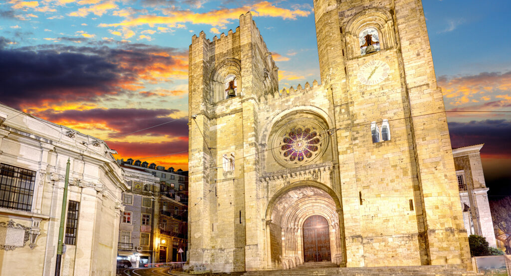 Exterior of Lisbon's Se Cathedral lit by evening sky