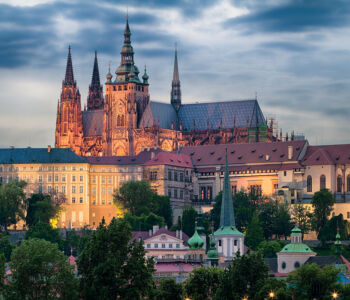 Prague Castle glowing above the city at twilight