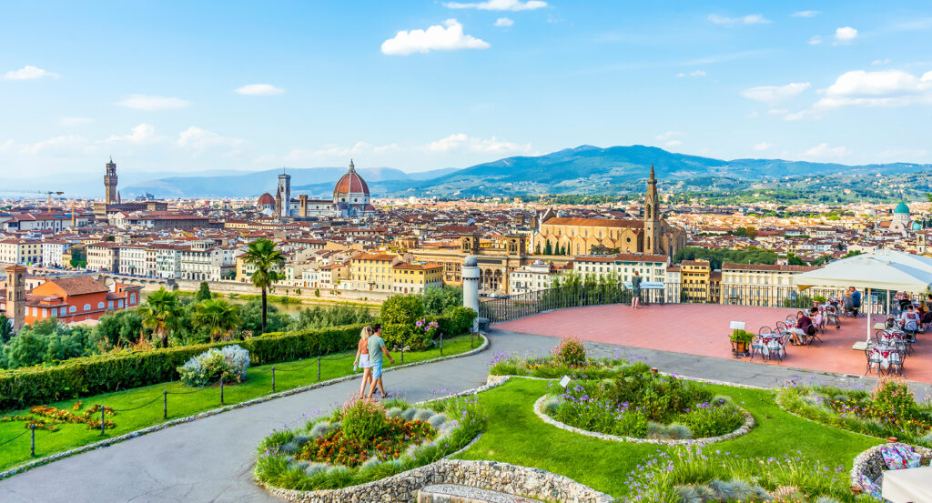 Tourists enjoying sunset view over Florence from Piazzale Michelangelo terrace