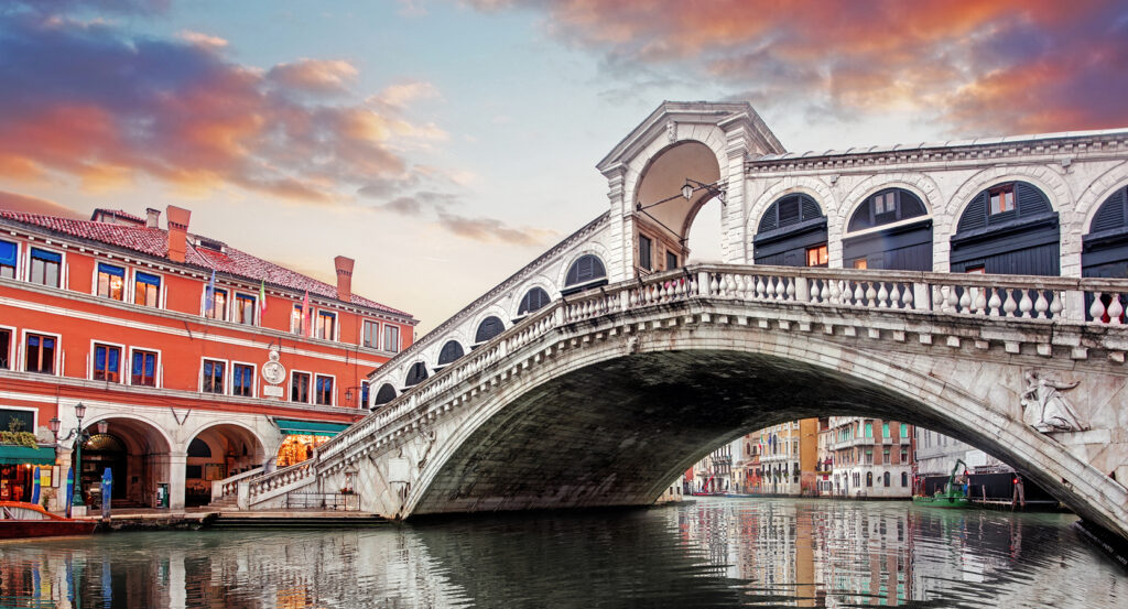 Reflections of the Rialto Bridge and Venetian buildings in the Grand Canal