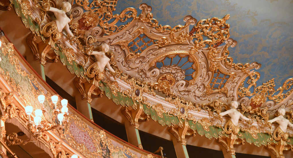 Close-up of Teatro La Fenice’s ornate ceiling with gilded details and cherubs