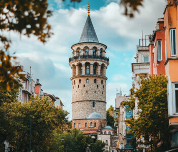 Galata Tower rising above the Istanbul skyline framed by colorful buildings