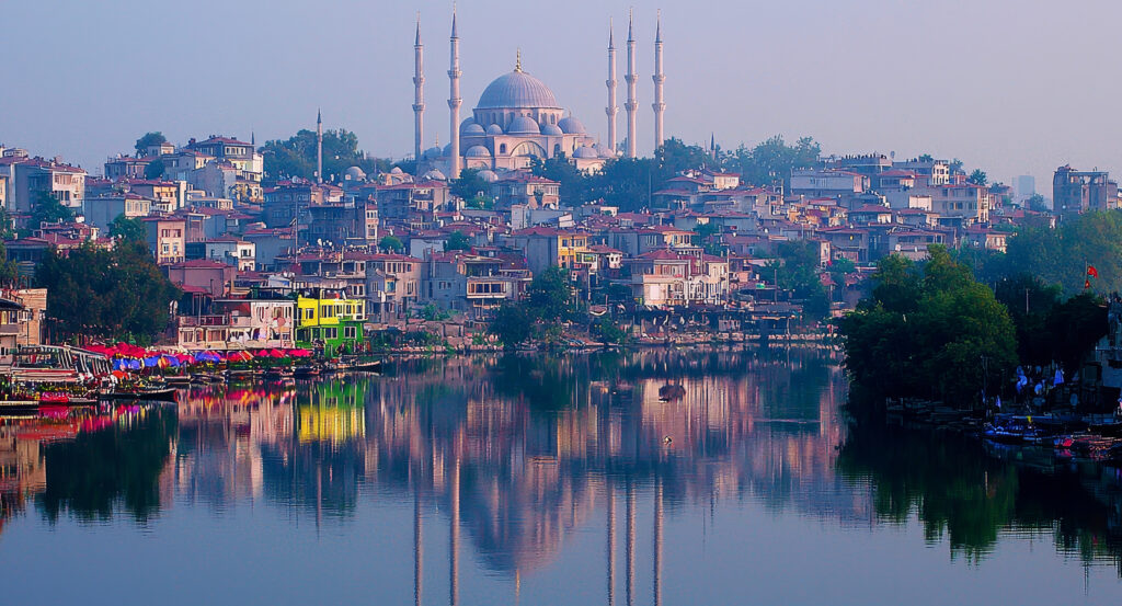 Panoramic view of Suleymaniye Mosque rising above Istanbul with colorful houses along the water.