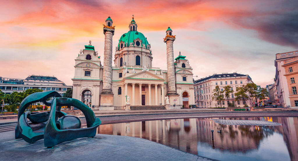 Karlskirche Vienna front view with twin columns and baroque dome mirrored in water