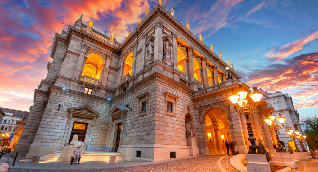 Hungarian State Opera House illuminated under dramatic evening sky