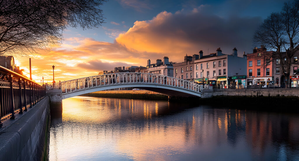 Iconic Ha’penny Bridge crossing the River Liffey in Dublin with glowing evening sky