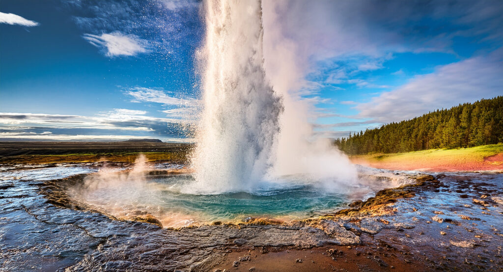 Golden Circle geyser eruption with steam and sky in Iceland