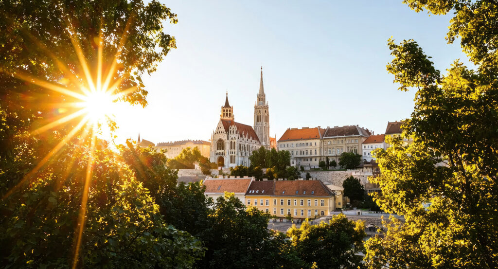 View of Matthias Church framed by trees and sunlight in Budapest
