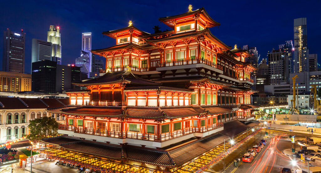 Exterior of Buddha Tooth Relic Temple with city skyline backdrop
