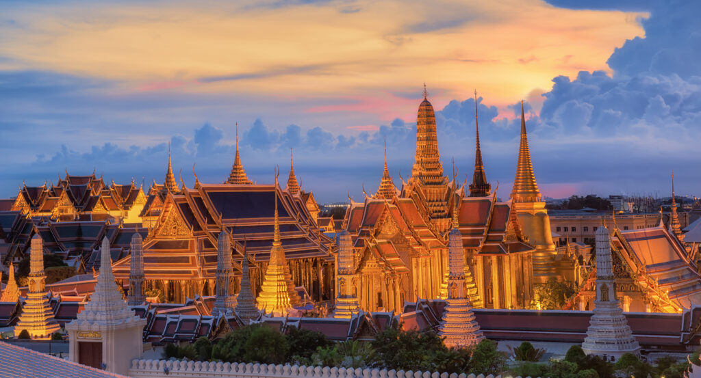 Temple view of Wat Phra Kaew with gilded spires and dramatic sky