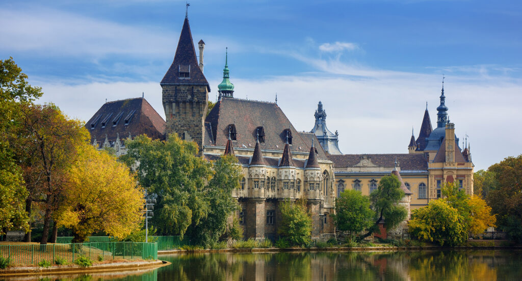 View of Vajdahunyad Castle in Budapest with lake and gothic towers under a clear sky