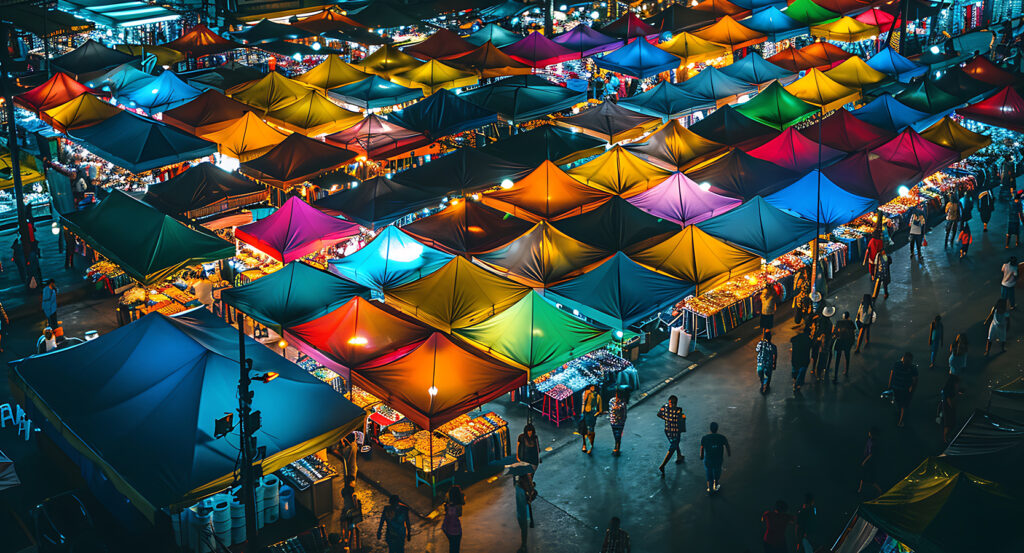 Brightly lit tents at Chatuchak Market bustling with visitors at night.