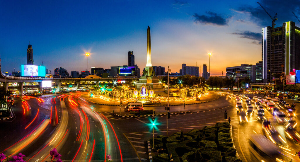 Traffic flowing around Victory Monument in Bangkok at sunset