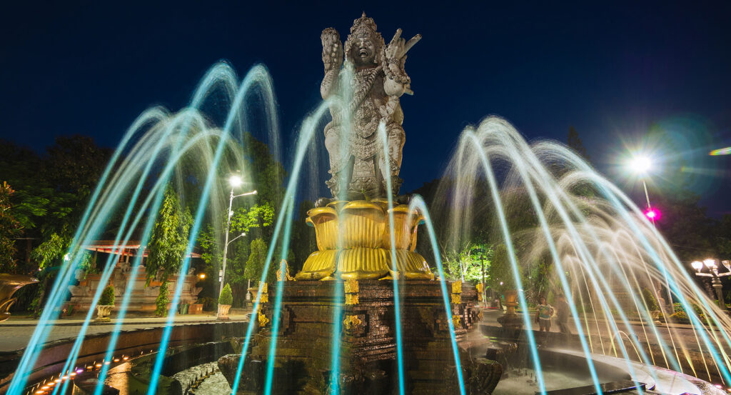 Four-faced Patung Catur Muka statue surrounded by water fountains in Bali