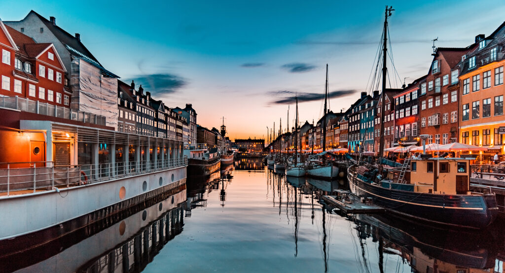 Colorful buildings and historic ships lining Nyhavn harbor in Copenhagen