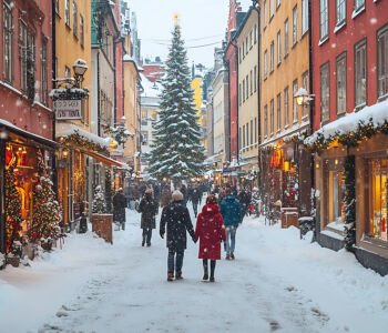 Snowy street in Gamla Stan, Stockholm, decorated with lights during winter.