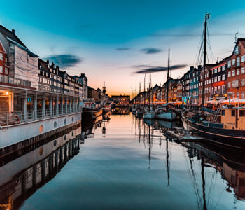 Nyhavn canal in Copenhagen at sunset with boats and colorful houses