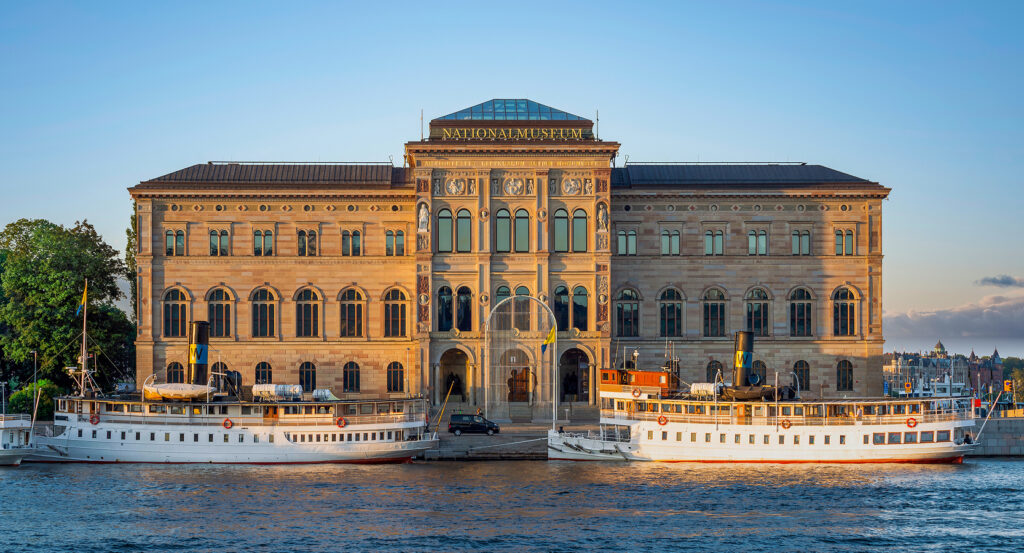 Stockholm's Nationalmuseum facade at sunset with reflection on water