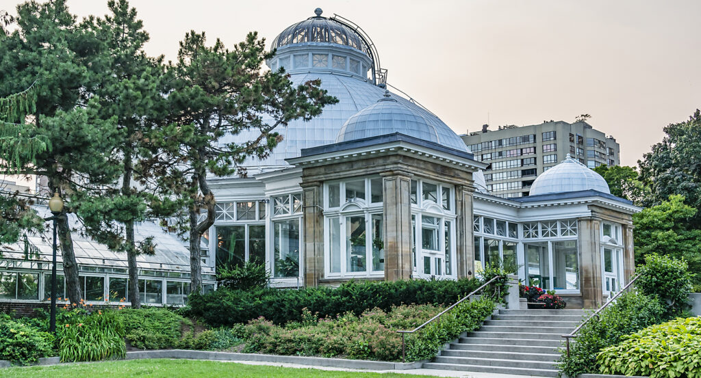 Historic greenhouse at Allan Gardens Conservatory in Toronto surrounded by trees