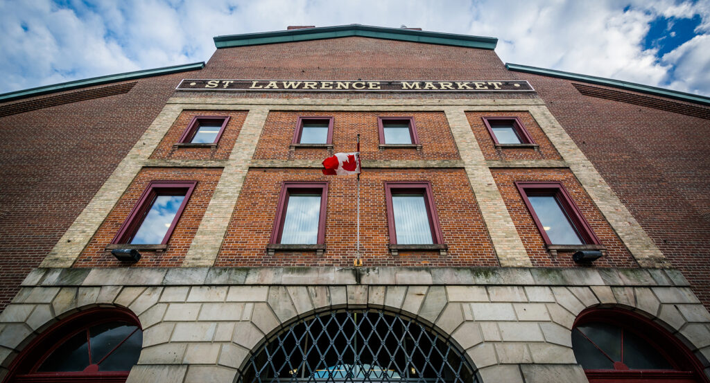 Historic brick facade of St. Lawrence Market with Canadian flag